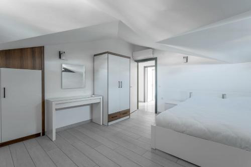 a white bedroom with a bed and a desk at minta suits in Kemer