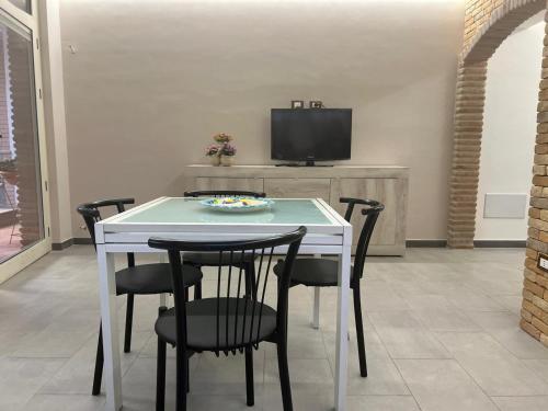 a dining room with a table and chairs and a tv at Casa Vacanza Riviera dei Saraceni in Trebisacce