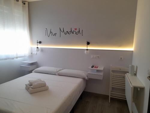 a bedroom with a white bed with a sign that reads ive married at CH Bueno in Madrid