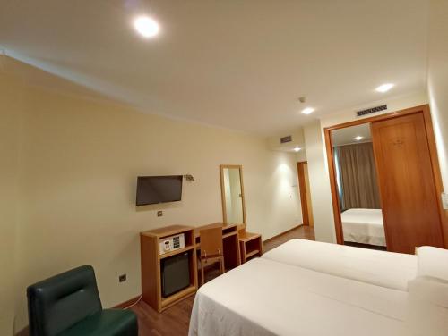 Habitación de hotel con cama y TV en Hotel Galaico, en Sanxenxo