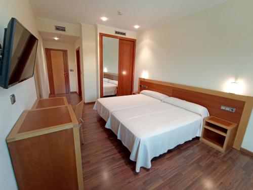 Habitación de hotel con cama y TV de pantalla plana. en Hotel Galaico, en Sanxenxo