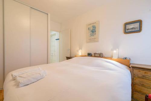 um quarto com uma cama branca e um espelho em Les 4 horizons au sein d' une résidence calme em Talant