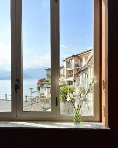 a window with a vase with white flowers in it at La Dama del Porto in Laveno-Mombello