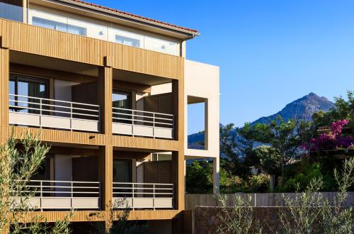 an apartment building with a mountain in the background at RESIDENCE SANTA MARIA in LʼÎle-Rousse