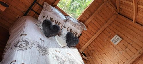 a bed in a wooden room with a teddy bear at Les Gîtes du Hameau avec piscine in Castelnau-sur-Gupie