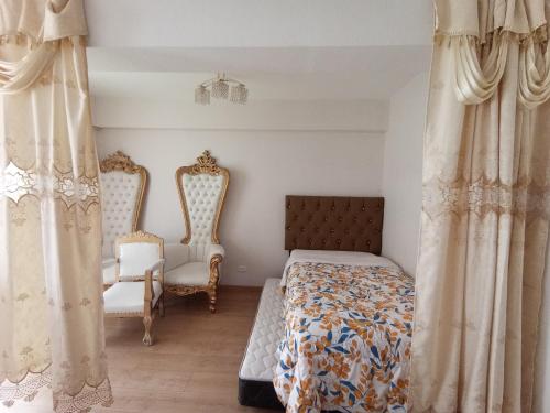 a bedroom with a bed and two chairs at VERSALLES APARTMENT in Lima