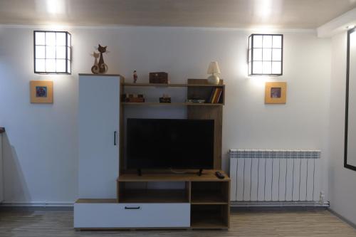 a living room with a flat screen tv on a stand at Old Friends Guesthouse in Gyumri