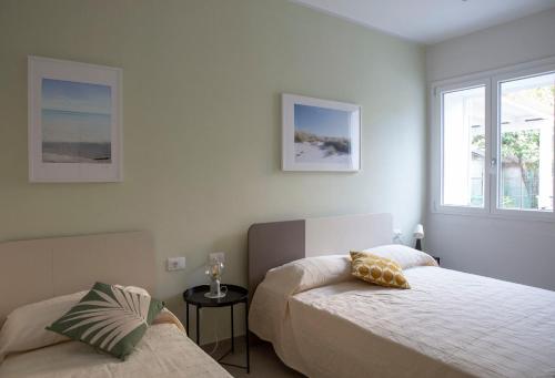a bedroom with two beds and two windows at Le case di vada/ appartamento le Dune in Vada