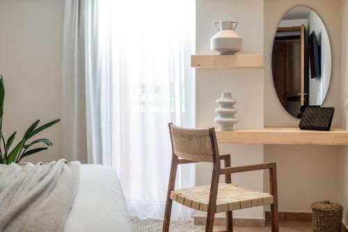 a bedroom with a desk and a chair and a mirror at Elèa Concept Hotel & Suites in Gouves