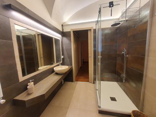 a bathroom with a sink and a glass shower at Il Nido Del Borgo in Genoa