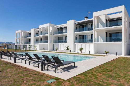 a villa with a swimming pool in front of a building at Oliva Suites in Oliva