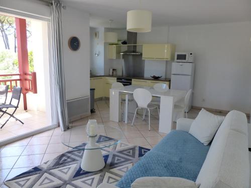 un salon avec un canapé blanc et une cuisine dans l'établissement Appartement Pour 4 Personnes- Residence L accalmie, à Capbreton