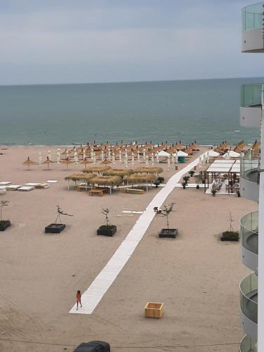 een strand met parasols en mensen op het strand bij SUNDREAM by the beach in Mamaia