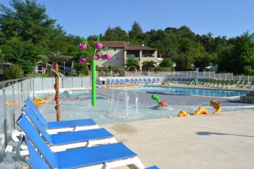 une piscine avec des chaises bleues et un parc aquatique dans l'établissement La Maison Roussel, à Rosières