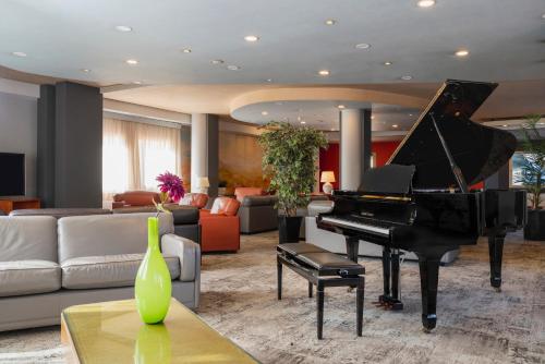 a living room with a piano and a couch at Perugia Park Hotel in Perugia