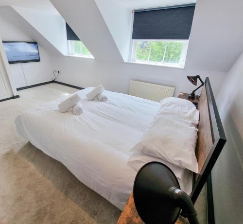 1 dormitorio con 1 cama blanca en el ático en City House in Nice Area - Smart TV's, 900mb Wifi, en Milton Keynes