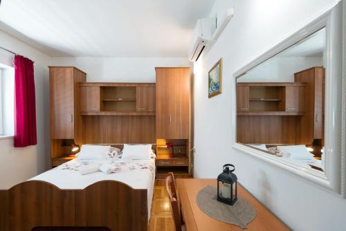 ein kleines Zimmer mit einem Bett und einem Spiegel in der Unterkunft Guesthouse Sanela in Pomena