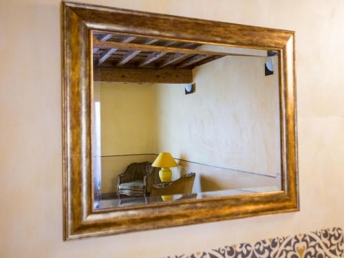 a mirror on a wall with a chair and a lamp at La Comédie de Pézenas - Appartements in Pézenas