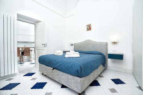 une chambre avec un lit dans une pièce blanche dans l'établissement La Finestra sul Corso, à Amalfi