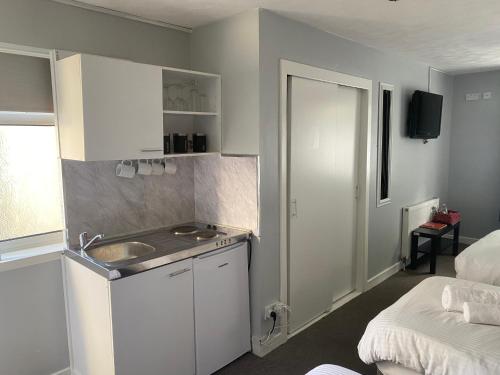 - une petite cuisine avec un évier et un lit dans l'établissement Harbourside Hotel, à Irvine