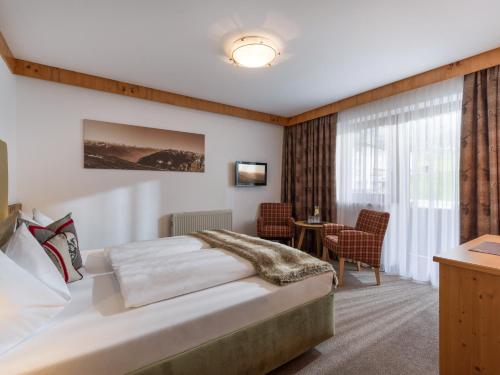 a hotel room with a bed and a desk at Hotel Landhaus Zillertal in Fügen