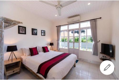 a bedroom with a large bed and a window at Beach House Apartment in Legian
