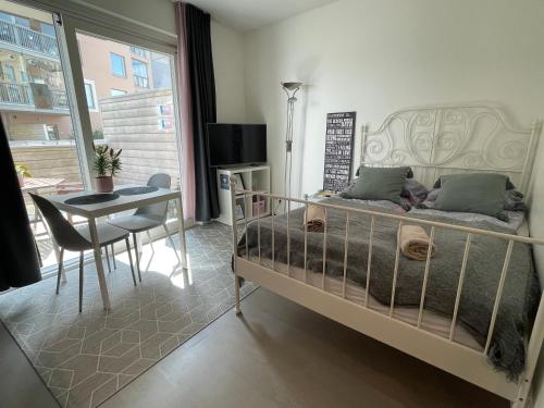 a bedroom with a bed and a table and a chair at The Seabreeze Apartment Turku in Turku