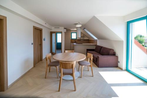 uma cozinha e sala de estar com mesa e cadeiras em Apartmány Na Zahradách em Lednice