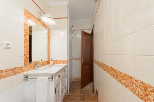 a bathroom with a sink and a mirror at Casa das Tulipas - Vila Nogueira de Azeitão in Villa Nogueira