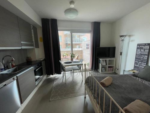 a room with a bed and a kitchen with a table at The Seabreeze Apartment Turku in Turku