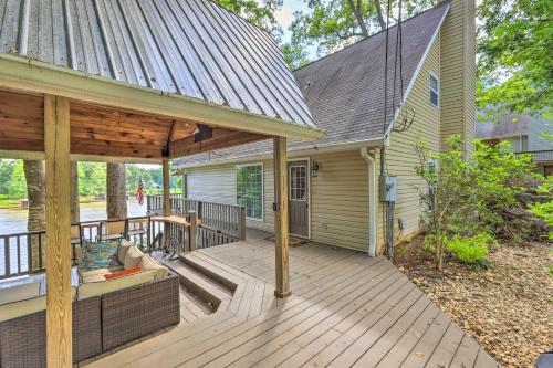 a porch of a house with a wooden deck at Lakefront Home with Entertainment Space and Dock! in Eatonton