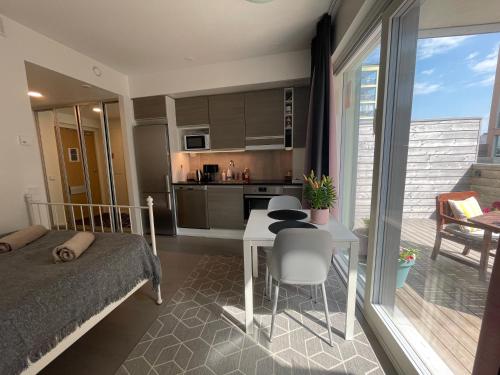 a bedroom with a bed and a table and a kitchen at The Seabreeze Apartment Turku in Turku
