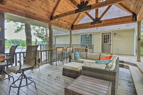 a screened in porch with a couch and chairs at Lakefront Home with Entertainment Space and Dock! in Eatonton