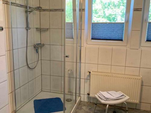 a bathroom with a shower with a blue rug at Haus Gorch Fock in Neuharlingersiel