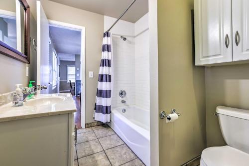 a bathroom with a sink and a tub and a toilet at 6 Mi to Old Market Home with BBQ-Ready Patio! in Omaha