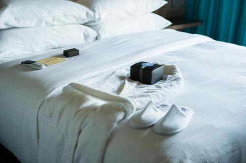 a remote control sitting on top of a white bed at Hotel Nyack, a JdV by Hyatt Hotel in Nyack