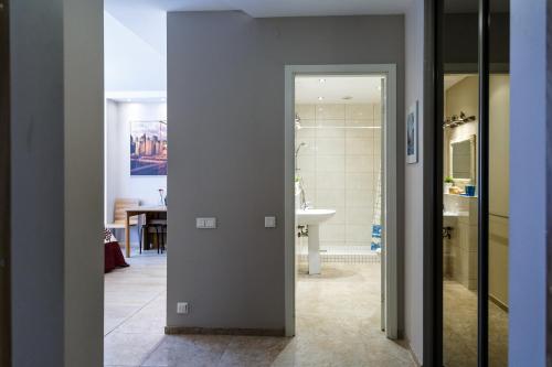 a doorway to a bathroom with a sink and a room at Hazel Apartment in Vilnius