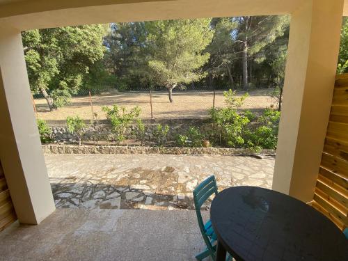 een tafel en stoelen op een veranda met uitzicht op een park bij la maison des cigales in Martigues