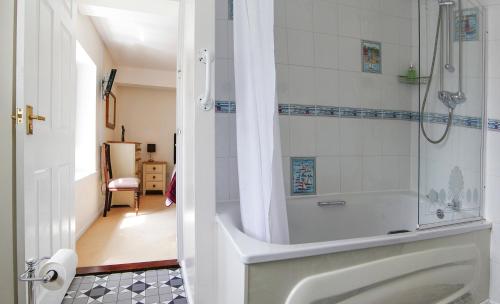 a bathroom with a shower and a bath tub at Leworthy Farmhouse Bed and Breakfast in Holsworthy