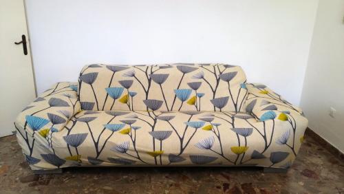 eine weiße Couch mit blauen und gelben Blumen drauf in der Unterkunft Appartamento Graziella, nel cuore di Ischia Porto in Ischia