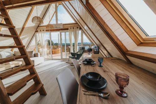 Habitación con mesa de madera y sillas en un ático en Woodparadise, en Nagyrada