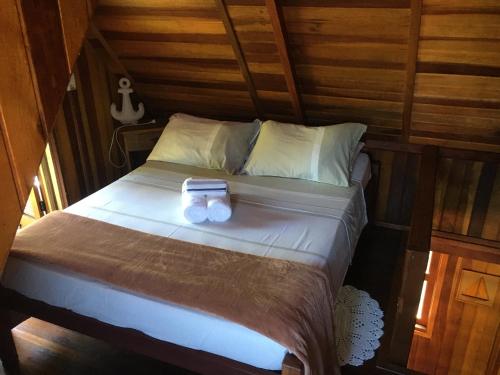 a bed with a box on it in a room at Pousada Refugio do Pirata in Trindade
