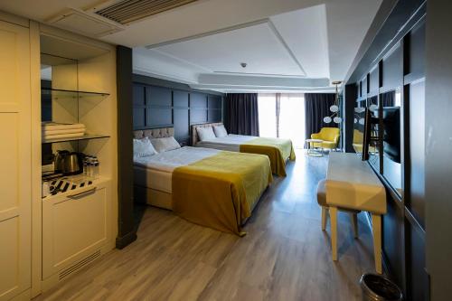 a hotel room with two beds and a desk at B LOFT HOTEL in Bursa