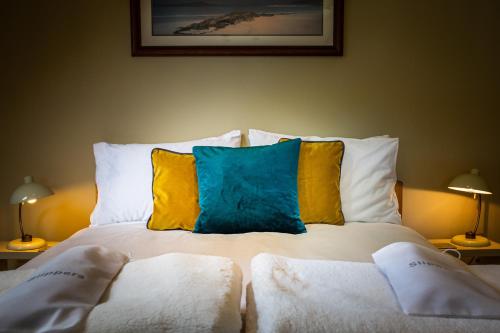 a bed with two pillows on it with two lamps at Cruickshanks Boutique B&B in Whiting Bay