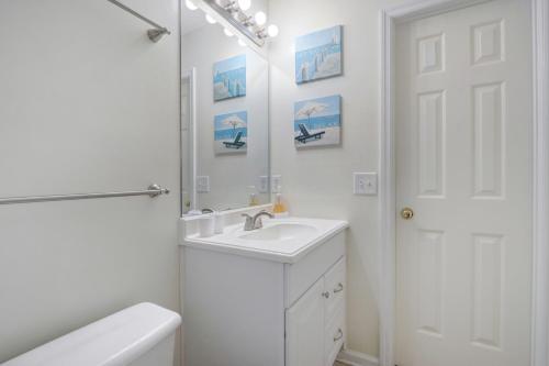 a white bathroom with a sink and a mirror at Pooler Travelers Retreat II - Entire House - in Savannah