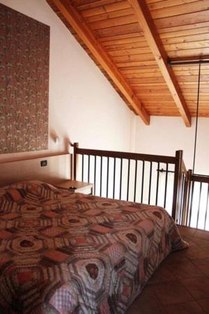 a bedroom with a bed and a wooden ceiling at Il Poggio Agrisport in Poirino