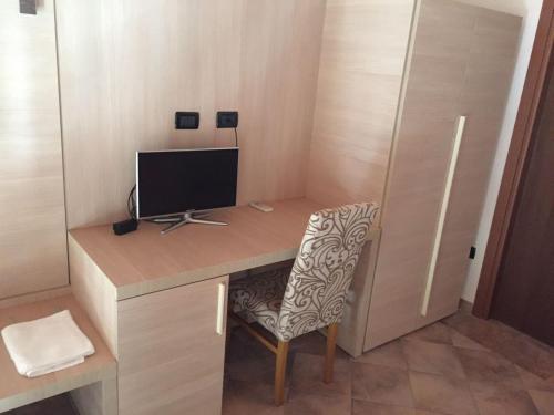 a desk with a monitor and a chair in a room at Il Poggio Agrisport in Poirino