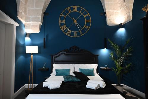 a bedroom with a large clock on a blue wall at Poesìa in Brindisi