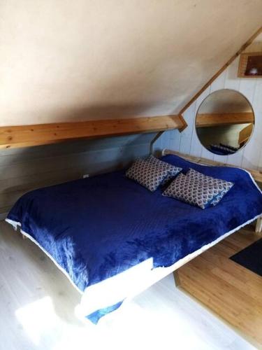 - un lit avec une couette bleue dans l'établissement Le Studio, à Saint-Augustin