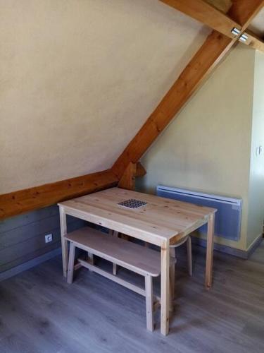 une table en bois et un banc dans le grenier dans l'établissement Le Studio, à Saint-Augustin